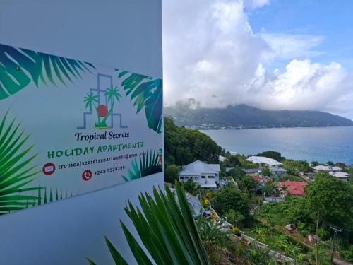 a sign for tropical resorts hawaiian airport and a view of the ocean at Tropical Secrets Holiday Apartments in Victoria