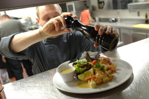 a man pouring a bottle of wine over a plate of food at Hotel The New Fox in Affligem
