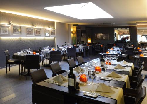 a dining room with tables and chairs in a restaurant at Hotel The New Fox in Affligem