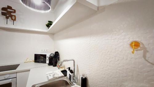 a kitchen with a sink and a white wall at Central Station Lux Downtown Apartman in Budapest