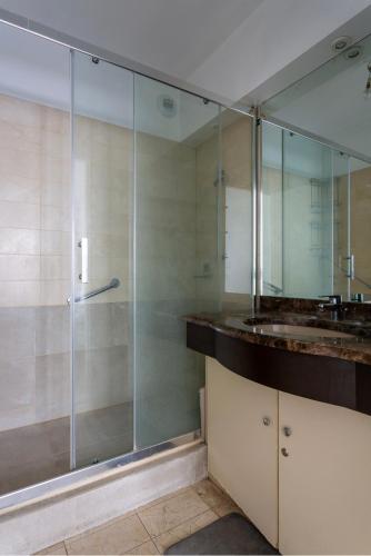 une salle de bain avec une douche en verre et un lavabo dans l'établissement Appartement champ elysee, à Neuilly-sur-Seine