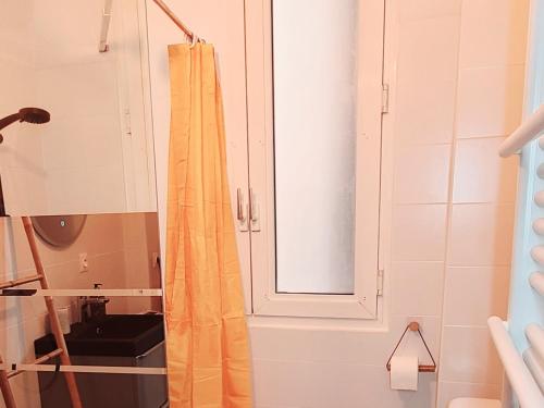 La salle de bains est pourvue d'un rideau de douche et d'un miroir. dans l'établissement Le Marceau Cour Extérieure, à Narbonne