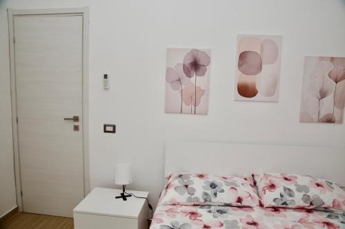 a bedroom with a bed and some pictures on the wall at Casa Amare Aeroporto Fiumicino in Focene
