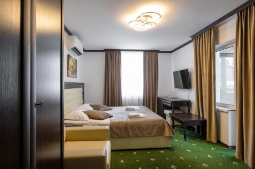 a bedroom with a bed and a desk and a window at Готельний комплекс Парламент, Яблуниця in Yablunytsya