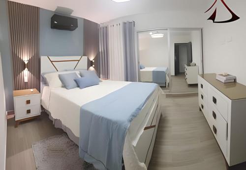 a bedroom with a large white bed and a mirror at Apto. El Escape Punta Cana, impuestos incluidos in Punta Cana