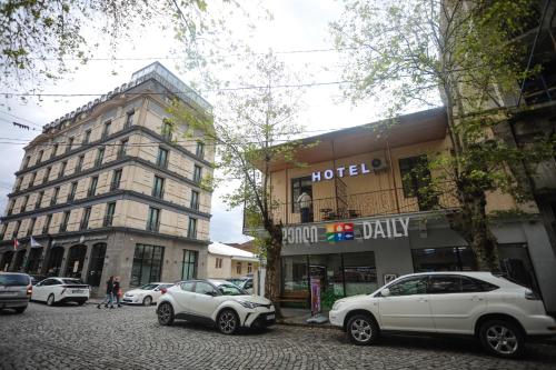 a street with cars parked in front of a hotel at hWB in Kutaisi