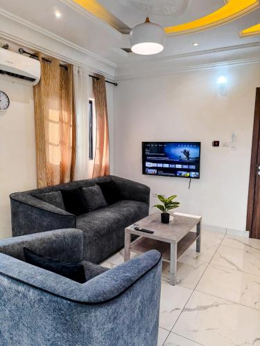 a living room with two couches and a tv at Novel Apartments in Limbe