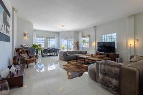 a living room with couches and a flat screen tv at Artiko Luxury Suites - Jan Thiel in Jan Thiel