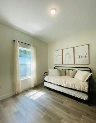 a bedroom with a bed and a large window at Nirvana Nature's Nook in Palm Coast