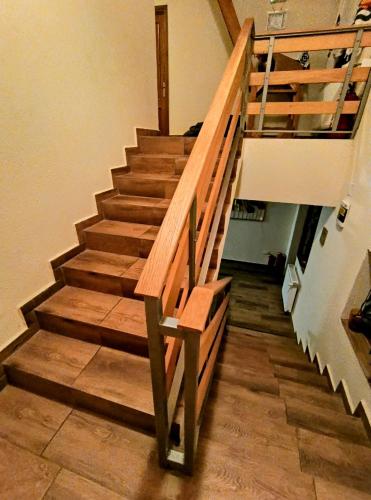 a staircase in a house with a wooden railing at Poiana Sașilor - Valea Doftanei in Trăisteni