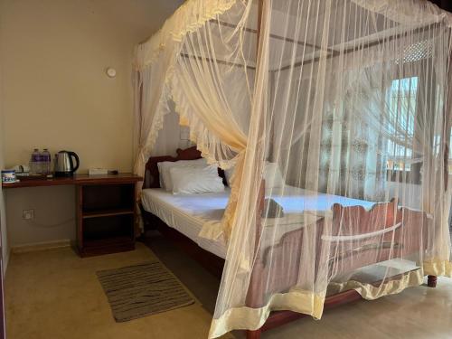 a bedroom with a canopy bed and a window at Brinkhouse Guesthouse , Unawatuna beach in Unawatuna