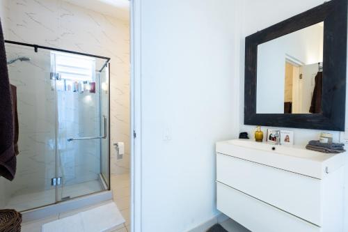a bathroom with a shower and a sink and a mirror at Artiko Luxury Suites - Jan Thiel in Jan Thiel