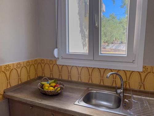 a bowl of fruit sitting on a counter next to a sink at Sivi's Vacation Homes in Skala Kallirachis