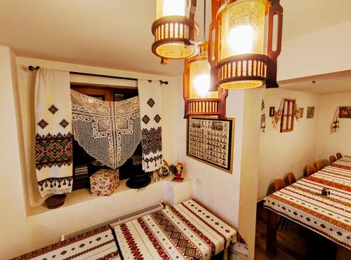 a room with two tables and a window with moroccan curtains at Poiana Sașilor - Valea Doftanei in Trăisteni