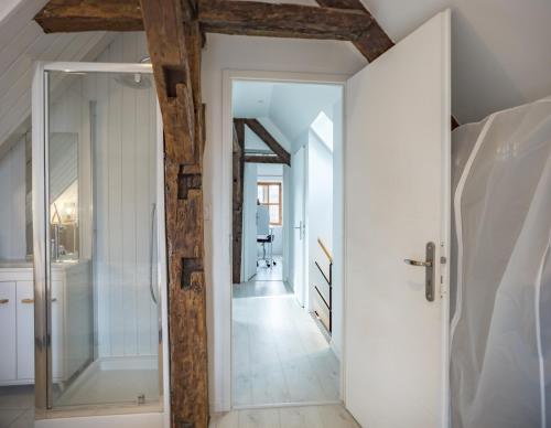 - un couloir avec des murs blancs et des poutres en bois dans l'établissement Duplex Saussier- Centre historique - ideal Groupe, à Troyes