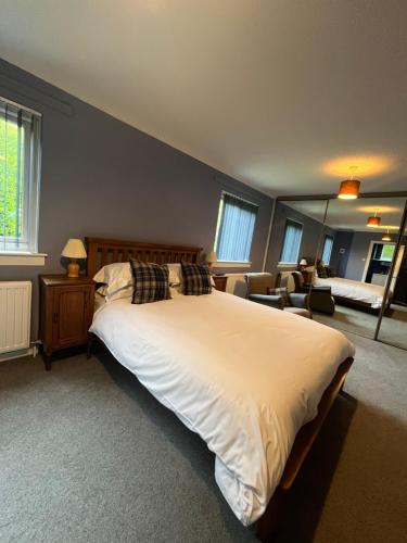 ein Schlafzimmer mit großem Bett und ein Wohnzimmer in der Unterkunft Runnymede House in Inverness