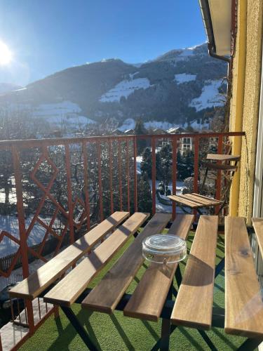 a wooden picnic table on a balcony with a view at Brunnhof Gastein in Bad Hofgastein