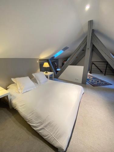 Cette chambre comprend un grand lit blanc et un escalier. dans l'établissement L'Écrin de Colmar - Hypercentre - Garage privé, à Colmar