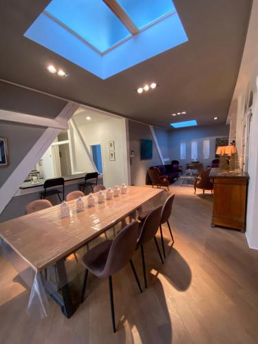 une grande table dans une pièce avec des chaises et une lucarne dans l'établissement L'Écrin de Colmar - Hypercentre - Garage privé, à Colmar