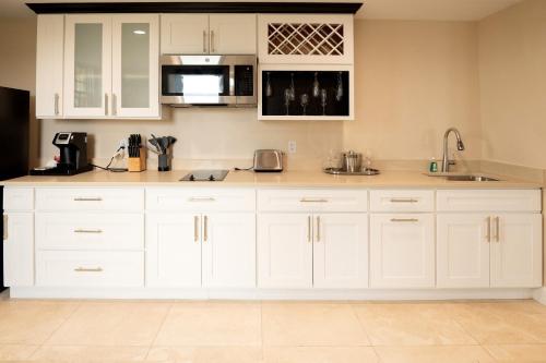 a white kitchen with white cabinets and appliances at The Americus Hotel, Trademark Collection by Wyndham in Allentown