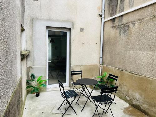un patio con tavolo e sedie in un edificio di Henri ll l Terrasse l Proche gare & Centre ville a Castres