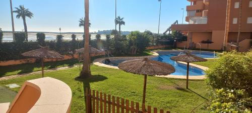 un complejo con piscina y sombrillas en Vista Atlántico, en Isla Cristina