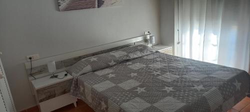 Un dormitorio con una cama con un edredón gris. en Vista Atlántico, en Isla Cristina