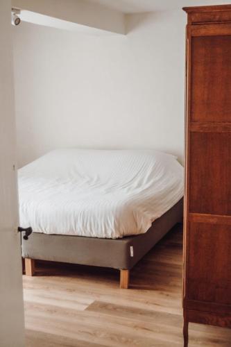 a bed sitting in a room next to a dresser at Vakantiewoning Wurfeldermolen in Maaseik