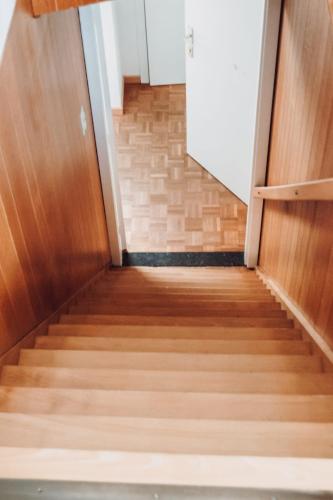 a staircase with wooden floors and a door at Vakantiewoning Wurfeldermolen in Maaseik
