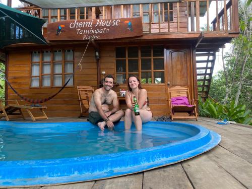 a man and a woman sitting in a pool in a tiny house at CHOMI HOUSE TAMBOPATA in Puerto Maldonado