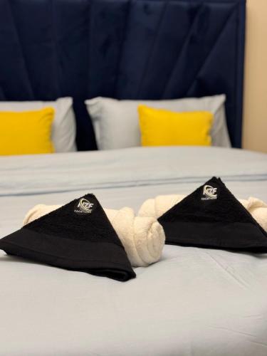a stuffed animal laying on a bed with two pillows at The Family Corner in Al Khān