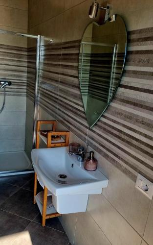 a bathroom with a sink and a large mirror at Denisa in Limanu