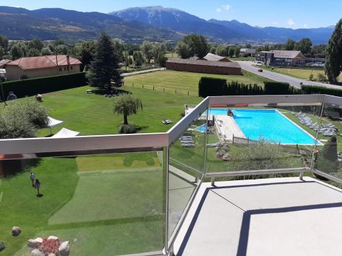 a view from the balcony of a house with a swimming pool at Puigcerda Park Hotel in Puigcerdà