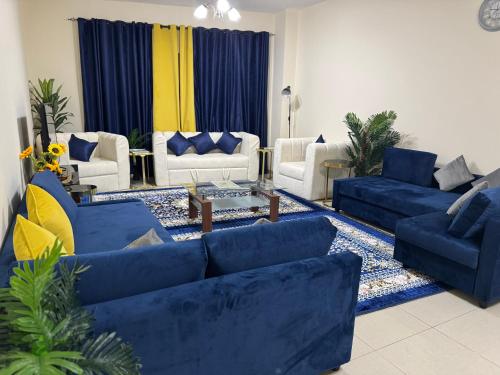 a large living room with blue couches and a table at The Family Corner in Al Khān