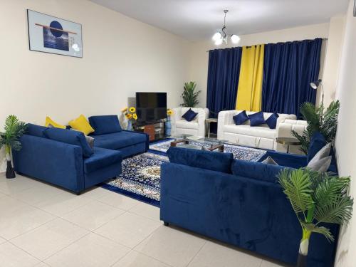 a living room with two blue couches at The Family Corner in Al Khān