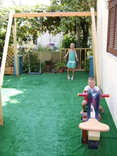 a young boy is riding on a playground at Hotel Elida in Platanes