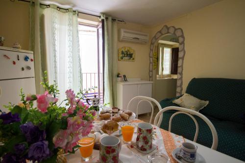 een eettafel met bloemen en sinaasappels erop. bij Alfa Quadro in Agrigento