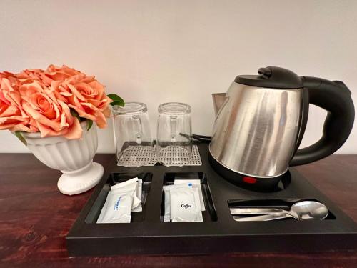 a tray with a tea kettle and a vase with flowers at Studio Two Condominium - Alabang, BLK - Northgate Cyberzone, Filinvest City, Alabang - Netflix-ready Fiber Wi-Fi in Manila