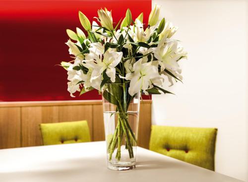 a vase of white flowers sitting on a table at Ferienhotel Bodensee in Berlingen