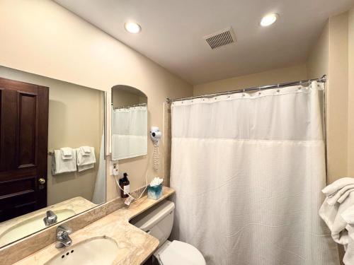 a bathroom with a white shower curtain and a sink at Copley House in Boston
