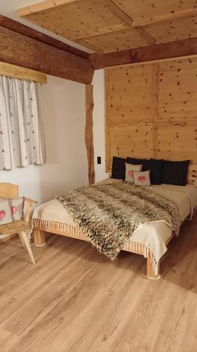 a bedroom with a large bed with a wooden ceiling at Rösslwirtin Appartement in Innsbruck