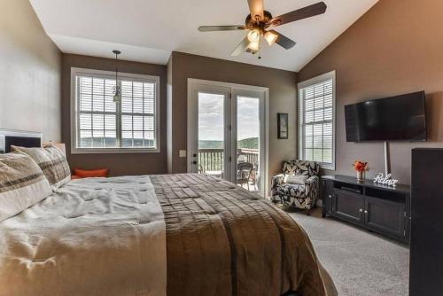 a bedroom with a large bed and a ceiling fan at Penthouse Lakeview Haven in Branson