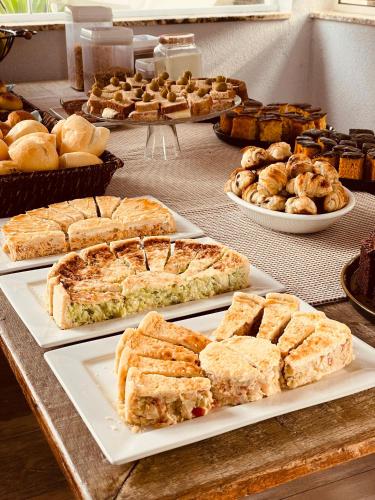 a buffet filled with different types of bread and pastries at Pousada Cantinho da Serra in Campos do Jordão