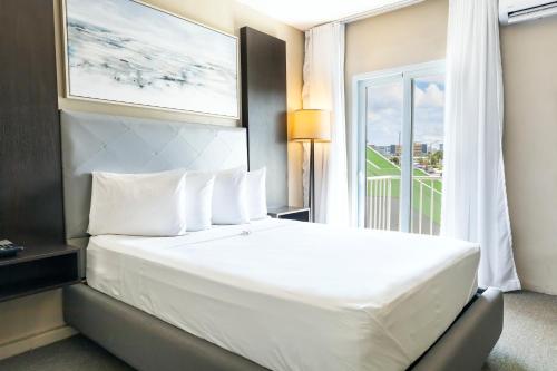 a hotel room with a large bed with a window at Villa Verde Inn in San Juan