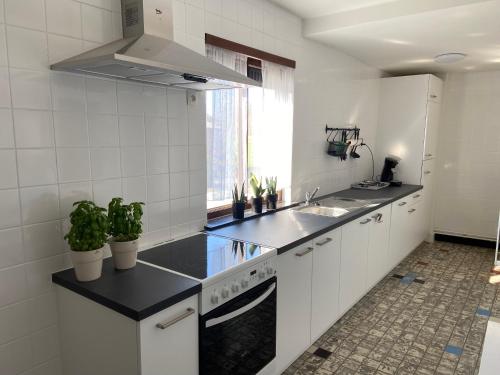 a kitchen with white cabinets and black counter tops at Vakantiewoning Wurfeldermolen in Maaseik