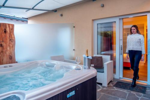 een vrouw die voor een bad staat bij Casa da Carmen Boutique & Private Spa in Mezzolombardo