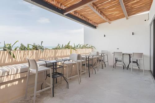 a row of tables and chairs on a patio at Zirene, Depto con jacuzzi priv in Chicxulub