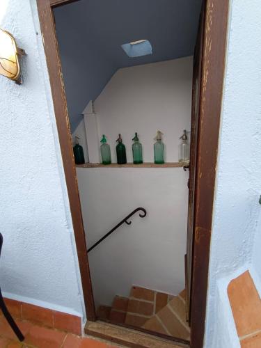 a stairway with green glass vases on a shelf at Casa Blava in Castelló d'Empúries