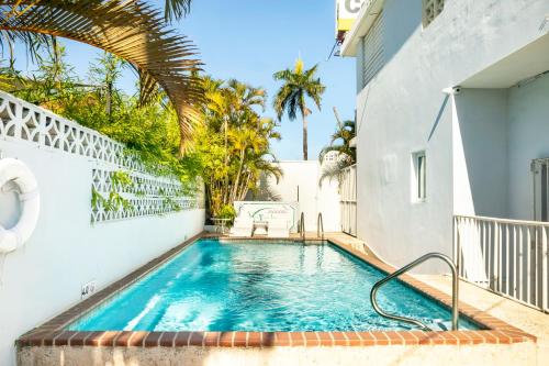 a swimming pool in the backyard of a house with a building at Villa Verde Inn in San Juan