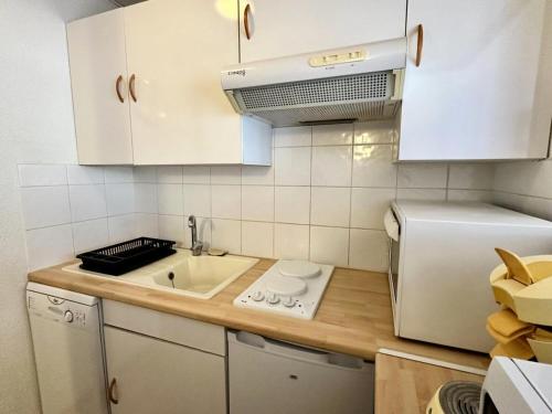 une petite cuisine avec un évier et un réfrigérateur dans l'établissement Résidence Le Tourmalet - maeva Home - Appartement 2 Pièces 6 personnes - Confort MAE-8081, à La Mongie